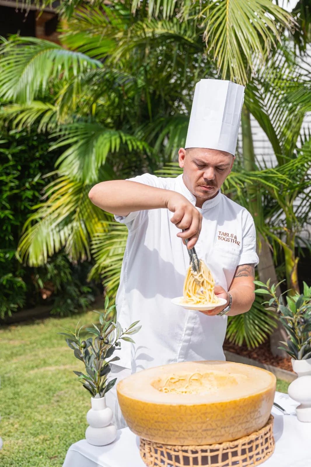 Chef Gabriele Franco serving pasta from a Grana Padano wheel